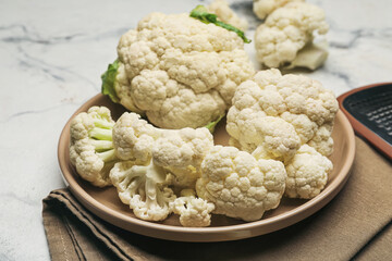 Plate with cauliflower cabbage on light background, closeup