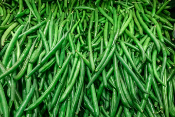 Fresh green beans piled on the market. Food background. Harvest