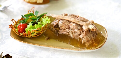 Jelly with meat, beef aspic, jelly on a plate in a restaurant, decorated with vegetables and herbs,...