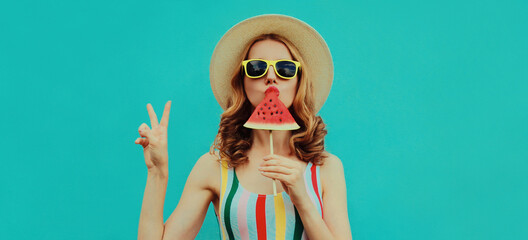 Summer portrait of stylish young woman eating a lollipop or ice cream shaped slice of watermelon...
