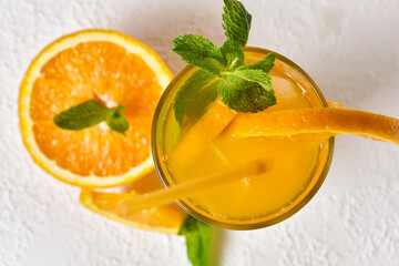 Orange drink with mint and ice in glass