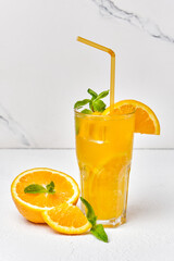 Orange drink with mint and ice in glass