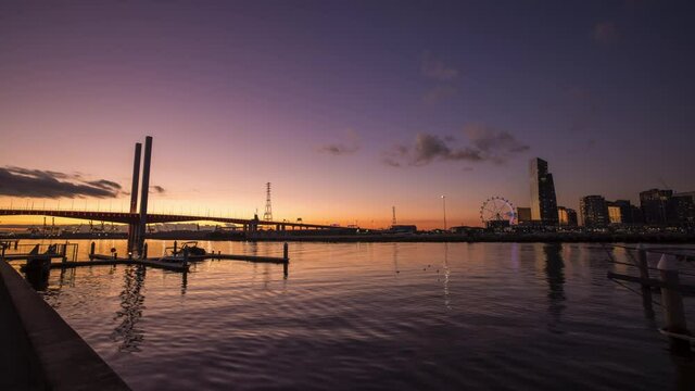 Sunset timelapse video of Bolte Bridge with Melbourne Star Observation Wheel at District Docklands in Melbourne CBD, Australia