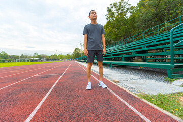 young Asian man athlete running and training on the running track.