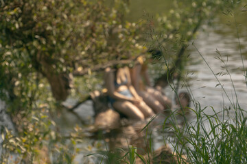 Young women in swimwear swim in the river in hot summers in Russia. Defocus photography
