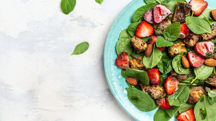 Strawberry with Spinach salad with chicken liver, almond and mint. Ketogenic diet dinner, Keto paleo lunch. diet menu, banner, recipe place for text, top view