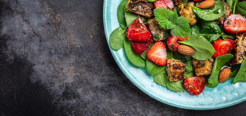 Spinach salad with strawberries, chicken liver, almond and mint. Healthy balanced food. Top view, above, banner