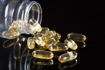 gold fish oil capsules on white background