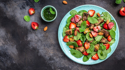 Fresh strawberry salad with spinach leaves, chicken liver, almond and mint. Delicious breakfast or snack, Clean eating, dieting food concept. top view