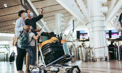 Obraz premium Family checking their flight timing at airport terminal