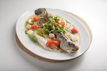 steamed fresh whole grouper fish with beancurd, tomato, sour vegetable and ginger in teo chew style asian halal menu