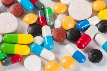 Assorted pharmaceutical medicine pills, tablets and capsules on white background