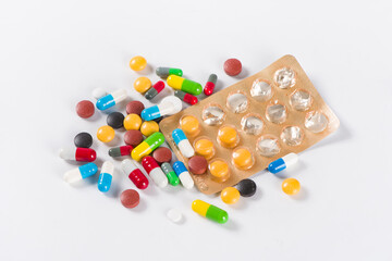 Assorted pharmaceutical medicine pills, tablets and capsules on white background