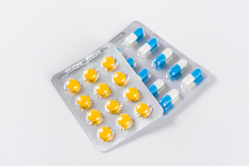 blue ande yellwo capsule pills in blister package.
