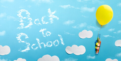 Balloon raising school supplies on blue background and message