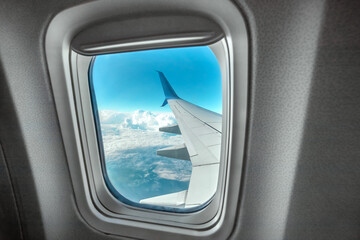 Fototapeta premium View from the window of a passenger plane above the clouds. International cargo transportation, air travel, transport, air travel, vacations. Copy space.