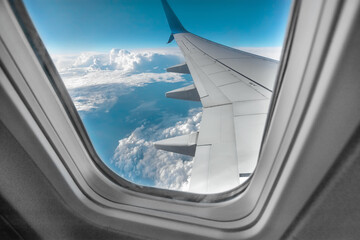 View from the window of a passenger plane above the clouds. International cargo transportation, air travel, transport, air travel, vacations. Copy space.