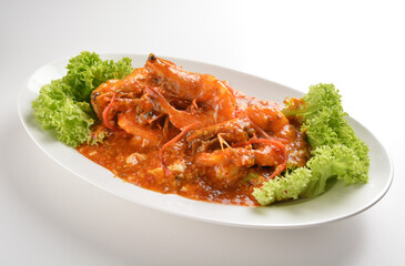 chef cook stir fried big tiger prawn seafood with chilli crab spicy red sauce in plate on white table seafood restaurant asian cafe halal chinese banquet menu
