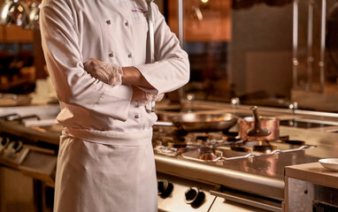 Hands of a chef folded on his stomach
