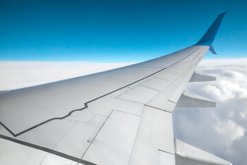 View from the window of a passenger plane above the clouds. International cargo transportation, air travel, transport, air travel, vacations. Copy space.