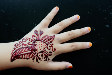 Henna ornaments on girl's hand closeup.