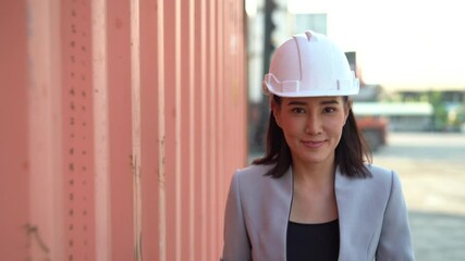 asian manager woman walking to checking list inventory  and control loading Containers box at warehouse logistic in Cargo . import export freight ship . worker transportation . looking  at camera