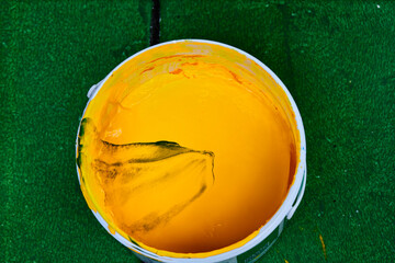 closeup used bucket of paint on the green floor