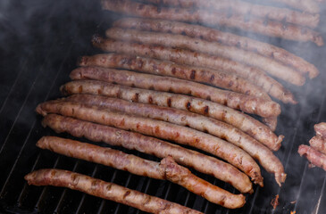 Smoking meat sausages on grill