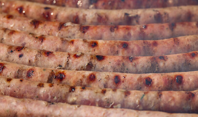 Smoking meat sausages on grill