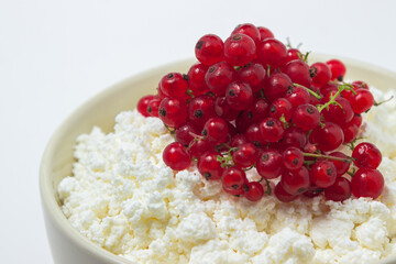 Cottage cheese with red currants on a white plate. Delicious and healthy breakfast. Proper nutrition