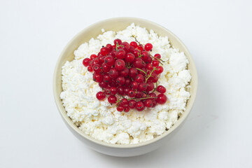 Cottage cheese with red currants on a white plate. Delicious and healthy breakfast. Proper nutrition