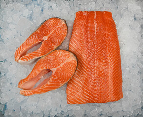 Close up raw salmon fish fillet and steak on ice