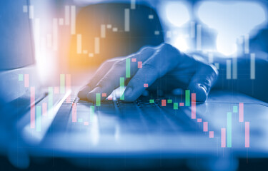Close up hand using computer laptop with trading graph, Business and Financial concept. 