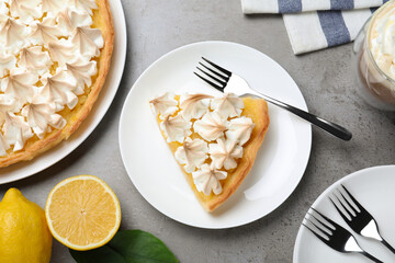 Cut delicious lemon meringue pie served on grey table, flat lay