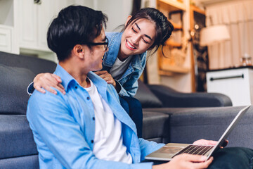 Young asian couple relaxing using laptop computer work and video conference meeting online chat.Creative business couple planning strategy analysis and brainstorm at home