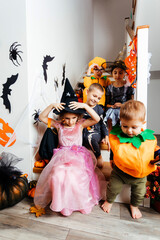 Halloween holiday party for children. Kids in costumes on staircase