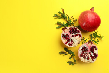 Flat lay composition with ripe pomegranates on yellow background. Space for text