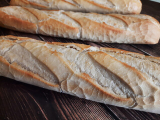 Bread bars and baguettes, baked in the bakery on wooden countertops