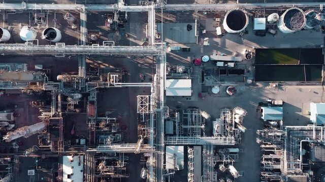 Top down aerial view of refinery plant with metal pipes and buildings in industry zone	