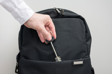 Man's hand with key to the apartment and backpack, man takes a key to the apartment, white...
