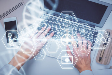 Double exposure of woman hands working on computer and DNA hologram drawing. Top View. Medical...