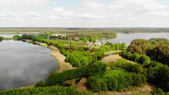 Dense Foliage On Lakeshore With Cottages At Nature Reserve Near Styporc, Chojnice County, Pomeranian Voivodeship, In Northern Poland. - Aerial Wide Shot