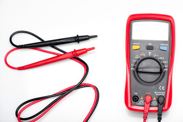 Electronic digital multimeter isolated on white with probes. Digital multimeter with red and black...