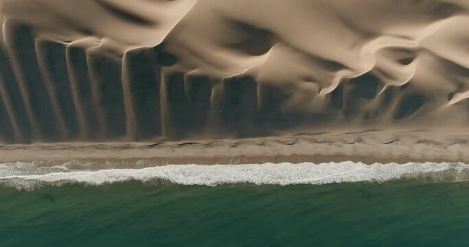 Spectacular high aerial view where the endless sand dunes meet the Atlantic Ocean in the Namib desert