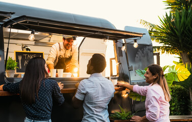 Young people buying meal from street food truck - Modern business and take away concept - 441937624