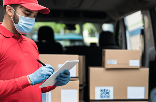 Delivery man wearing face protective mask to avoid corona virus spread - Young express courier working during coronavirus outbreak - Deliver and online buying concept