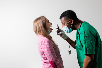 Obraz premium Doctor uses smartphone light to check patient's throat