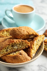 Tasty cantucci and cup of aromatic coffee on white marble table, closeup. Traditional Italian almond biscuits