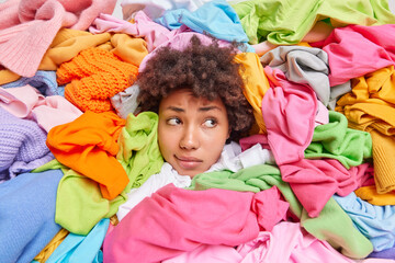 Curly haired woman collects clothes items in good condition to consignment shop or thrift store...
