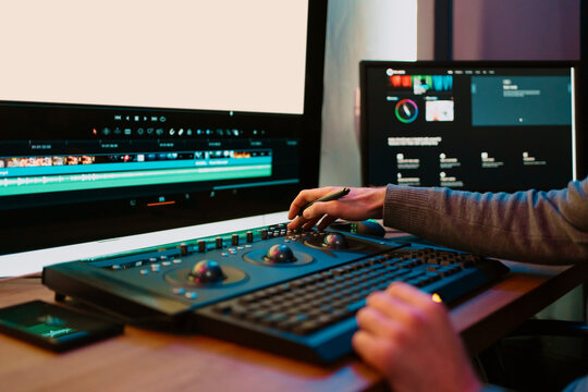 Attractive Male Video Editor Works with Footage or Video on His Personal Computer, he Works in Creative Office Studio or home. Neon lights